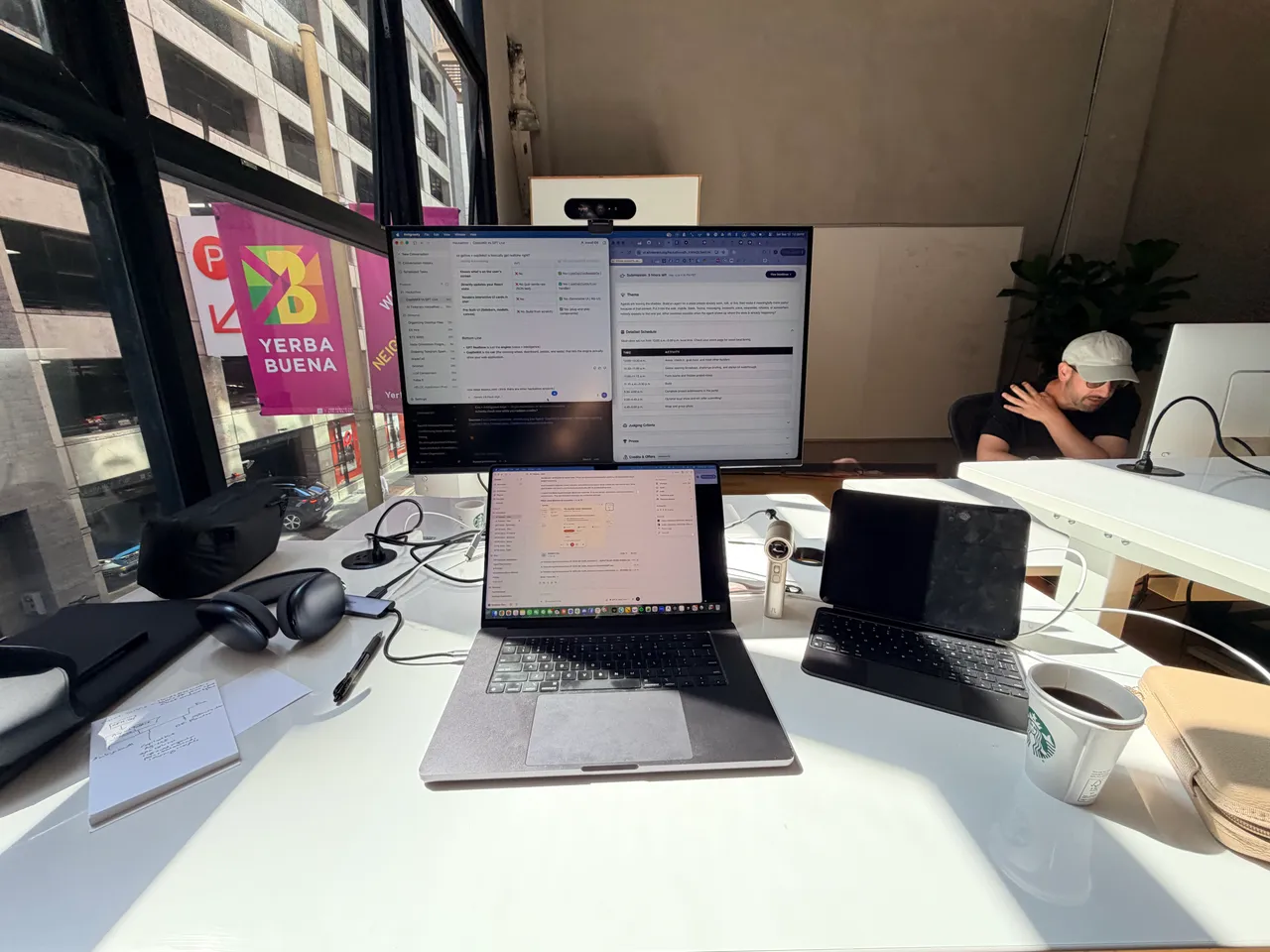 The hackathon build setup with a laptop, monitor, and voice recorder.