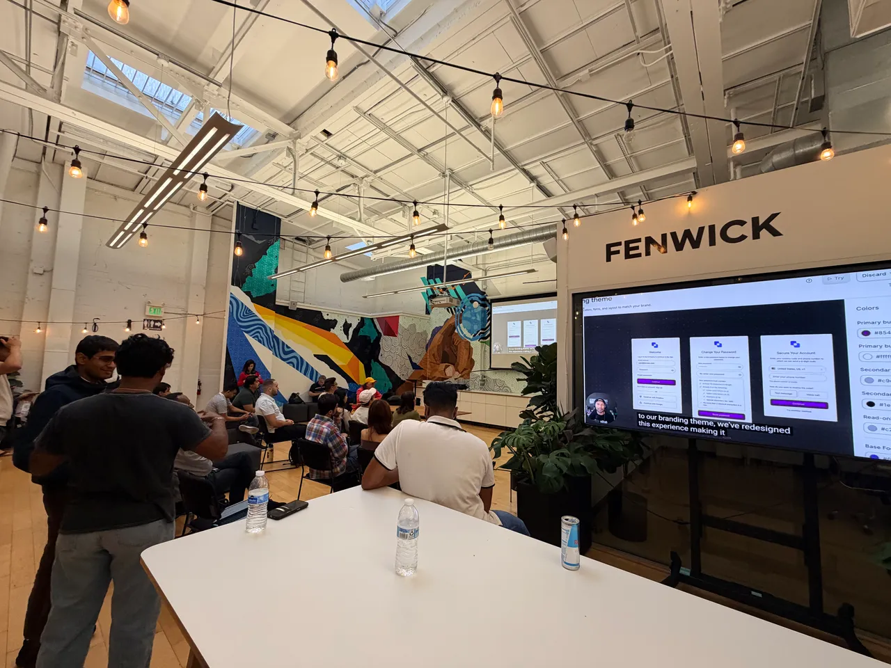 Hackathon attendees watching a presentation in the event space.